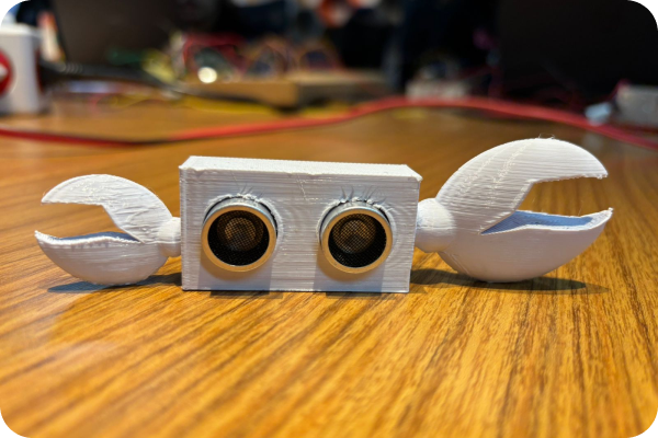 A foto mostra um módulo de sensor de distância, com o sensor dentro de uma estrutura impressa em 3D que possui patinhas de caranguejo.