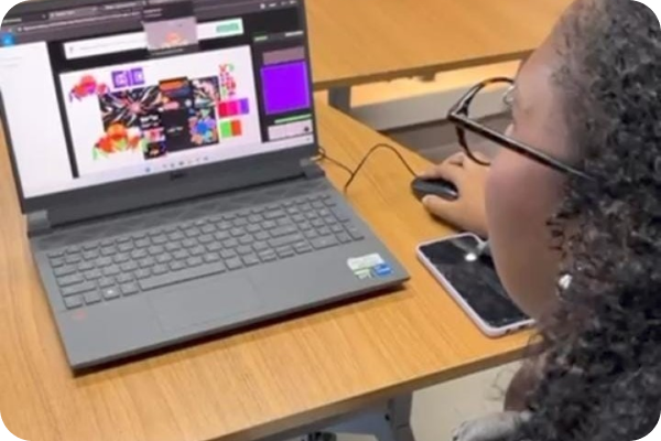 A foto retrata um notebook com elementos visuais pouco detalhados, mostrando uma mulher de lado, capturada de trás, sem que seu rosto seja visível.
